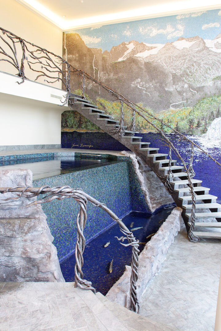 Custom pool with water features, mosaic wall, and metal work.